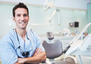 smiling-male-dentist-in-exam-room