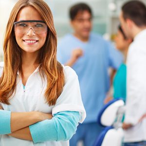 female-dentist-smiling-with-arms-crossed-at-a-dental-office-close