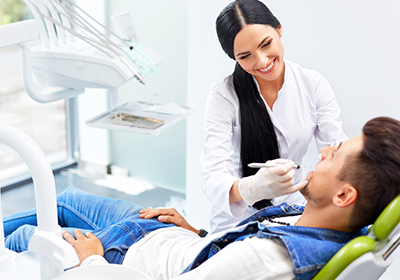 female-dentist-and-male-patient-having-his-teeth-examined